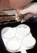 Squirt small amount of milk into each cup from each teat-only use 2 cups for goats